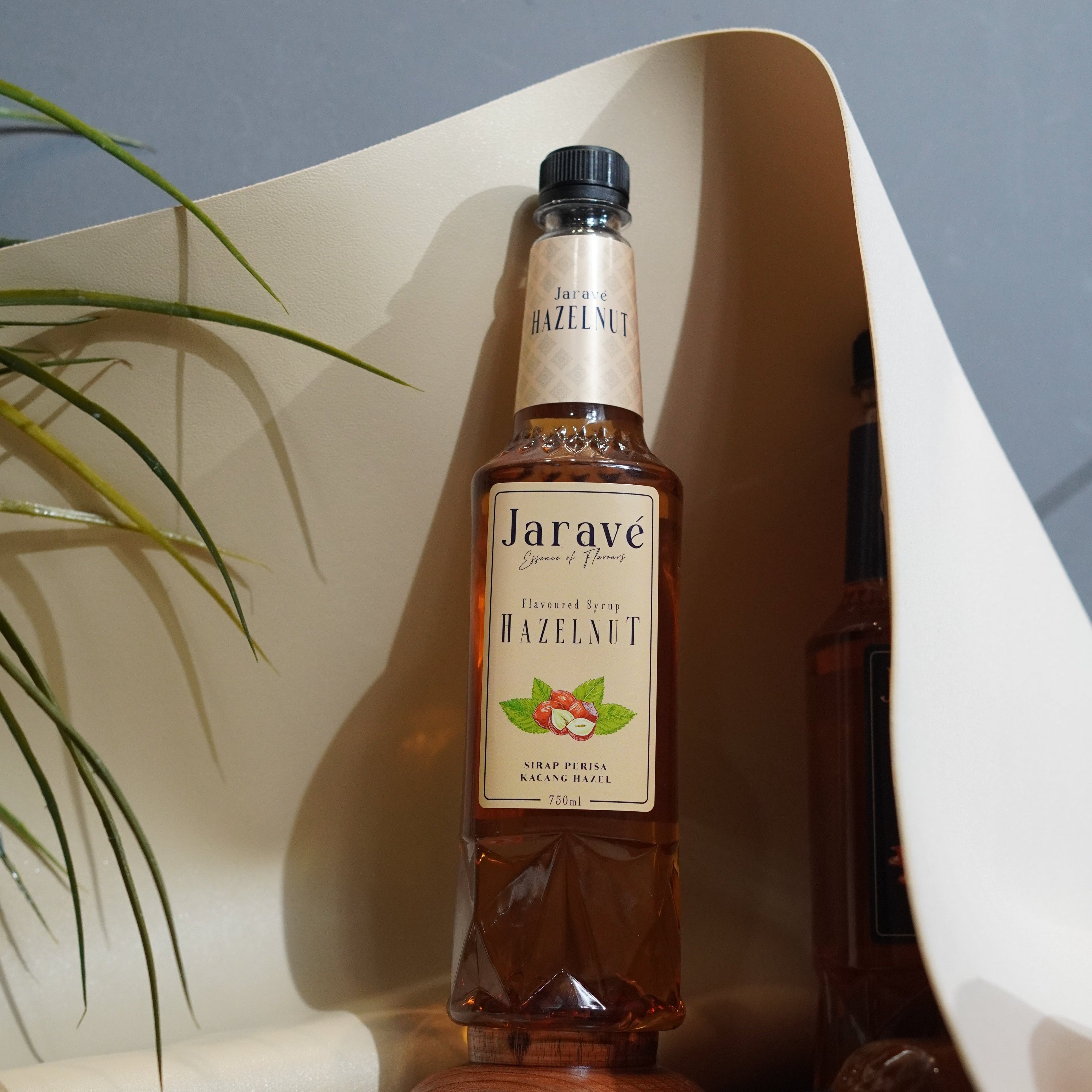 "Bottle of Jarave hazelnut on a reflective surface with a blurred background"