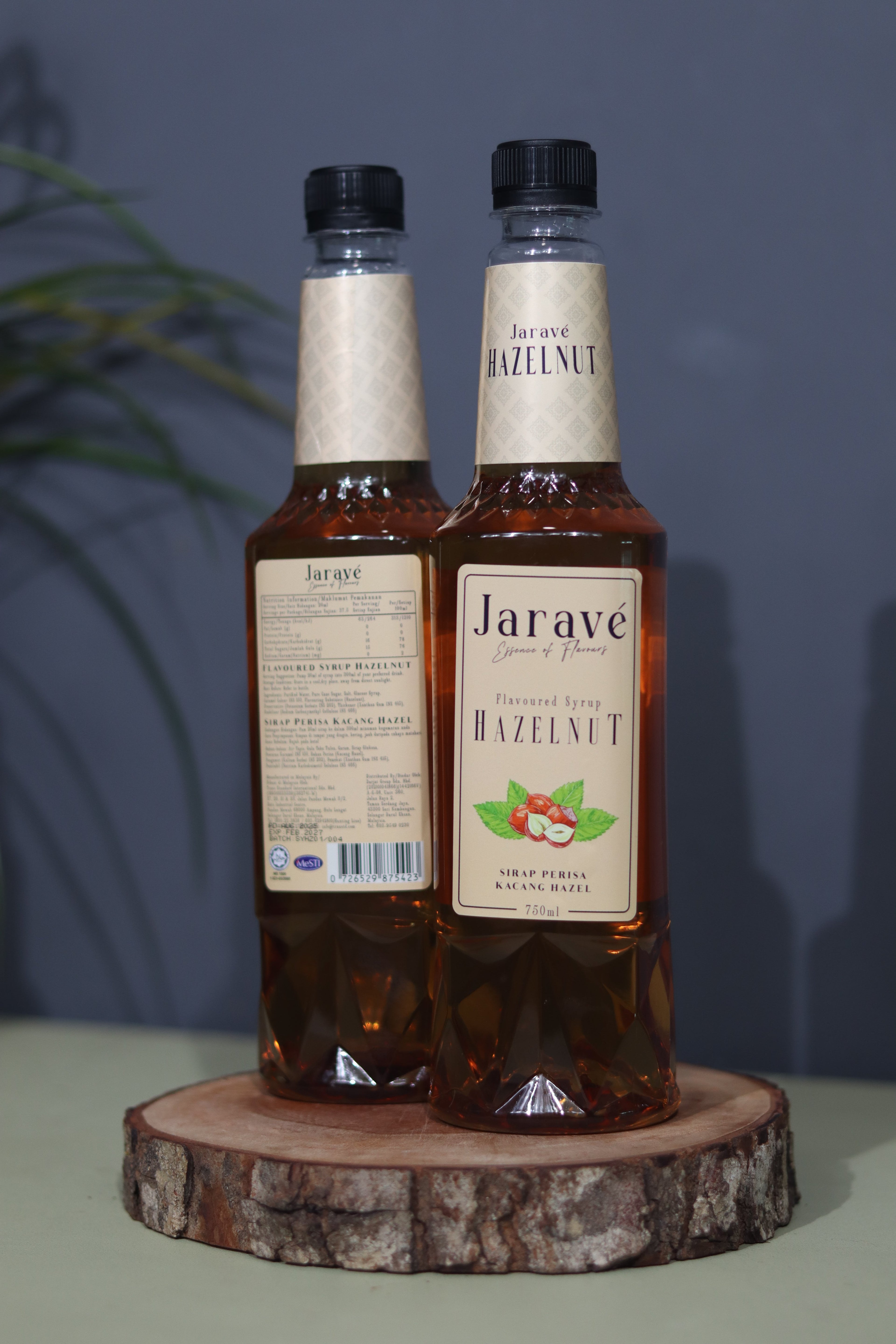 "Two bottles of Jarave hazelnut syrup on a wooden stand with a blurred background"